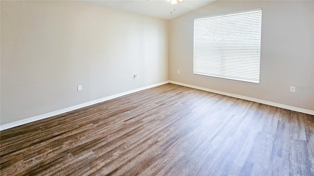 spare room featuring ceiling fan, baseboards, lofted ceiling, and wood finished floors