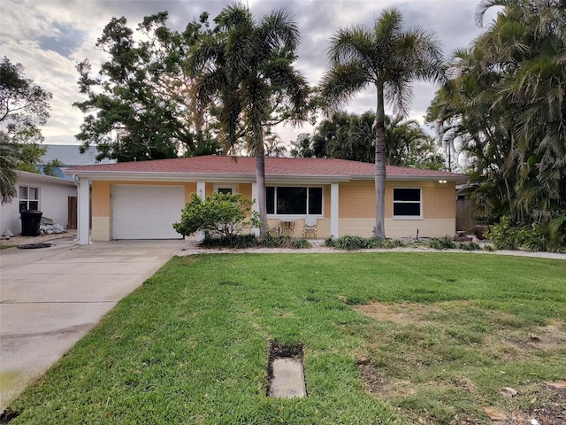 ranch-style house with driveway, a garage, and a front lawn