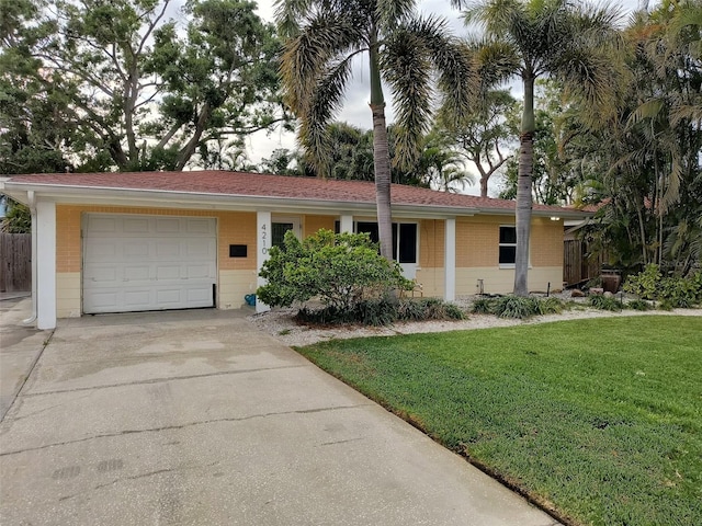 single story home with fence, a garage, a front yard, brick siding, and driveway