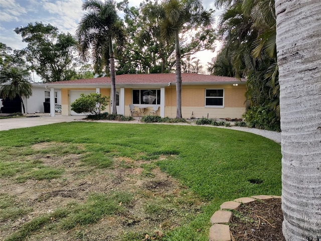 ranch-style home featuring driveway, a front yard, and a garage