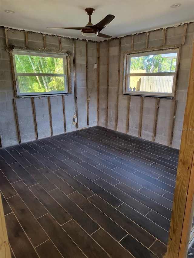 basement with ceiling fan and dark wood-type flooring