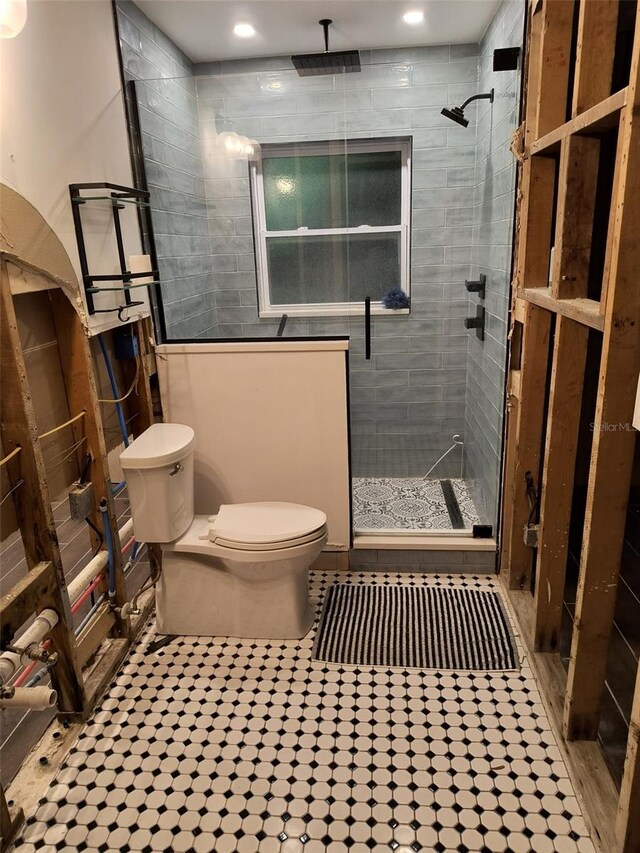 bathroom featuring toilet and a shower stall
