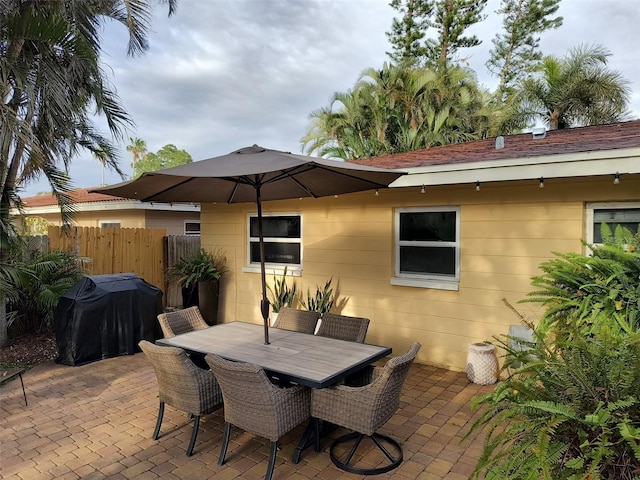view of patio / terrace featuring outdoor dining space, fence, and a grill