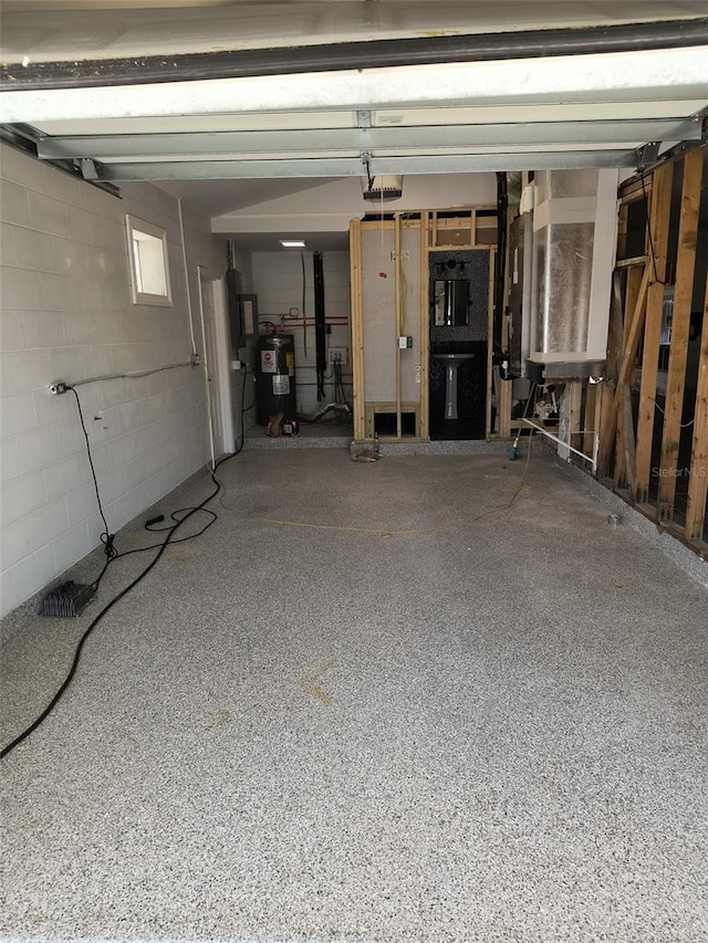 garage featuring water heater, concrete block wall, and a garage door opener