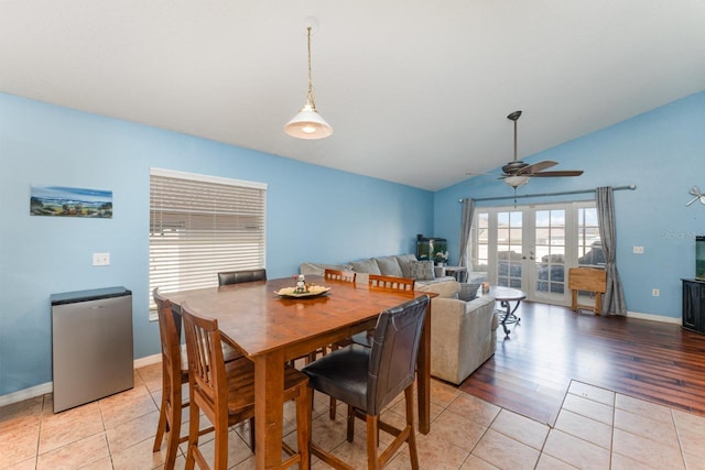 dining room with french doors, lofted ceiling, baseboards, and light tile patterned flooring