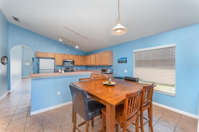 dining room featuring arched walkways, light tile patterned floors, lofted ceiling, and visible vents