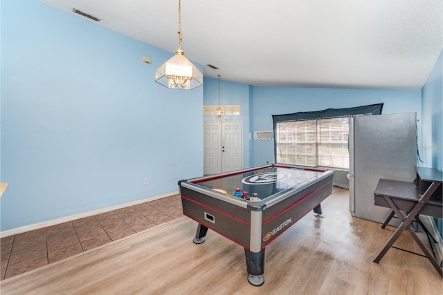 rec room featuring visible vents, wood finished floors, baseboards, and vaulted ceiling