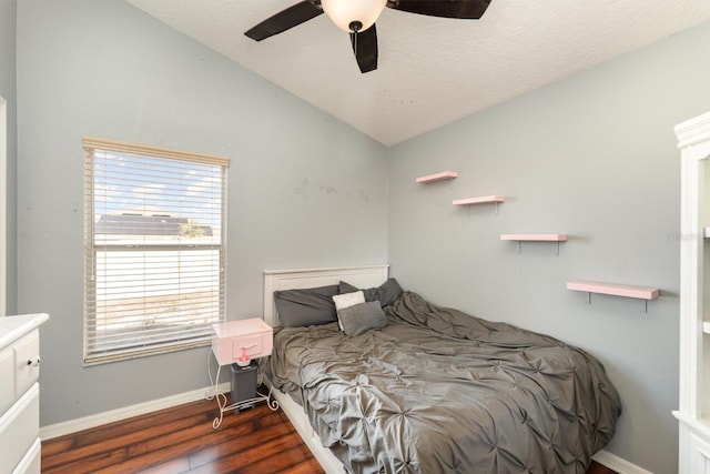 bedroom with ceiling fan, baseboards, vaulted ceiling, wood finished floors, and a textured ceiling