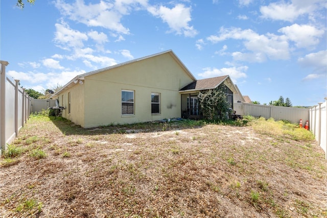 rear view of property with stucco siding and a fenced backyard