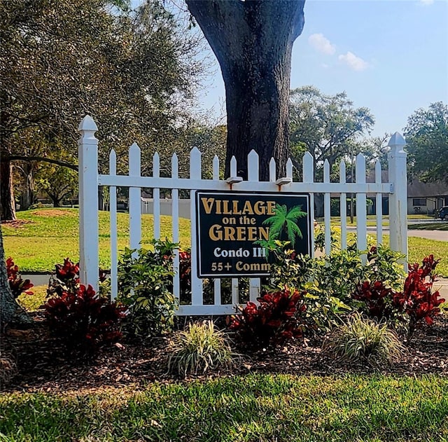 community sign featuring a lawn and fence