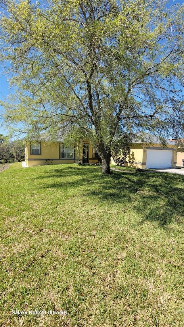 view of yard featuring driveway and an attached garage