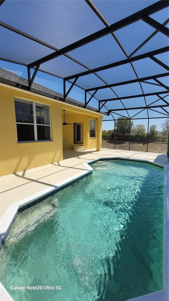 pool with a lanai and a patio area