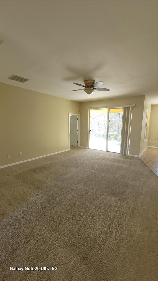 spare room featuring visible vents, light carpet, baseboards, and a ceiling fan