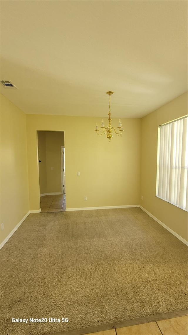 empty room with visible vents, light colored carpet, baseboards, and an inviting chandelier