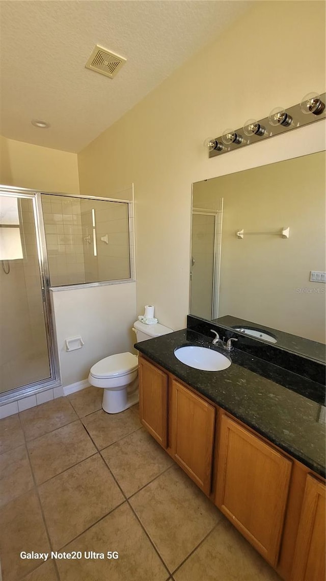 full bath featuring vanity, visible vents, a shower stall, tile patterned floors, and toilet