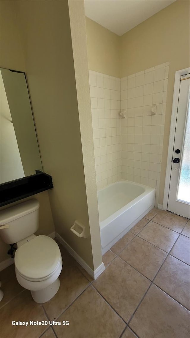 bathroom featuring baseboards, toilet, and tile patterned flooring