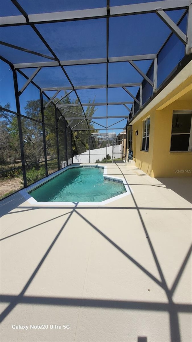 pool featuring a patio area and glass enclosure