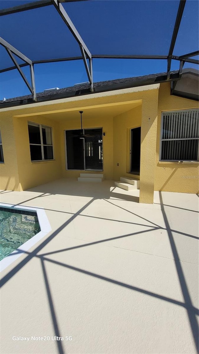 back of house with a lanai, stucco siding, and a patio