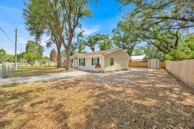 2415 Sutton Rd, Lakeland, FL 33810 - rear view of property with a storage unit, a fenced backyard, an outbuilding, and stucco siding