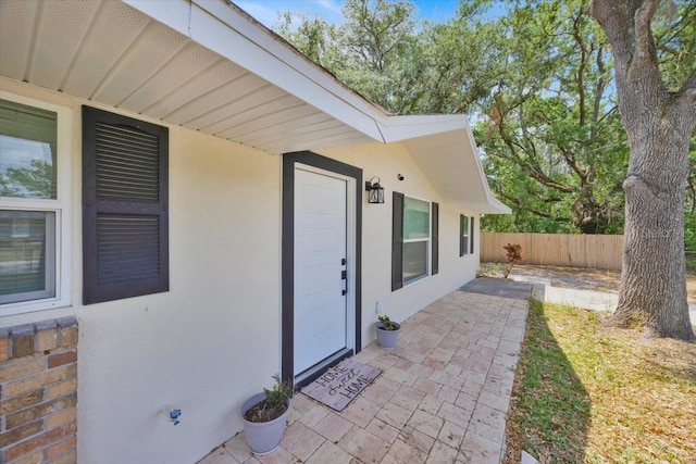 2415 Sutton Rd, Lakeland, FL 33810 - property entrance featuring stucco siding, fence, and a patio