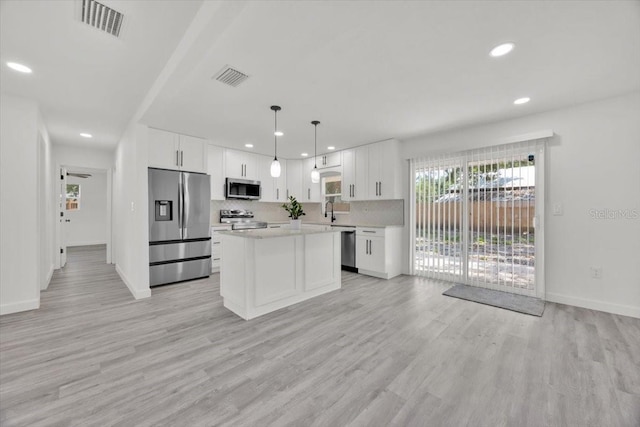 2415 Sutton Rd, Lakeland, FL 33810 - kitchen with appliances with stainless steel finishes, light countertops, recessed lighting, white cabinetry, and light wood-type flooring