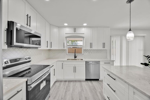 2415 Sutton Rd, Lakeland, FL 33810 - kitchen with appliances with stainless steel finishes, a sink, white cabinets, light stone counters, and recessed lighting