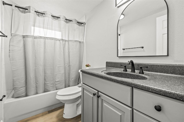 bathroom featuring vanity, toilet, wood finished floors, and shower / bath combo with shower curtain