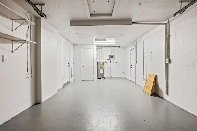 garage with electric water heater and concrete block wall