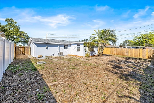 rear view of property with a fenced backyard and stucco siding