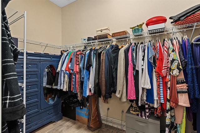 walk in closet with wood finished floors