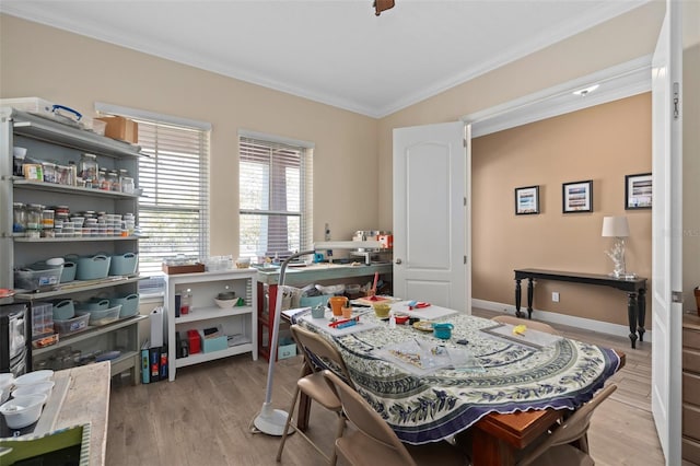 dining room featuring ornamental molding, baseboards, and wood finished floors