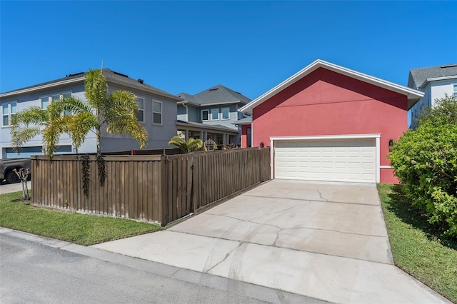 view of front of property with stucco siding, an attached garage, driveway, and fence