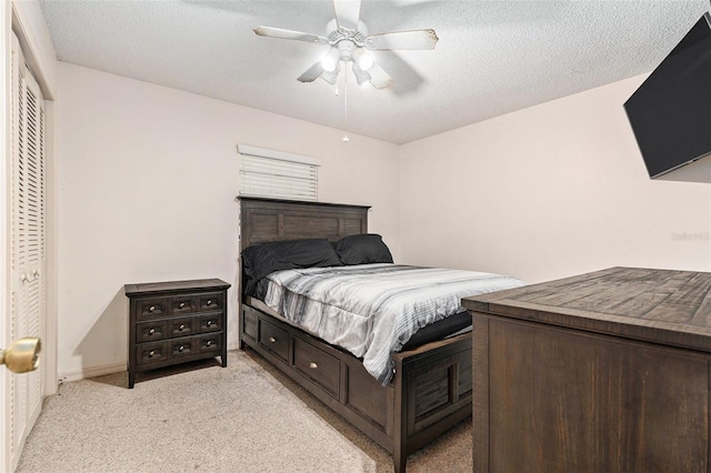 bedroom featuring a textured ceiling, ceiling fan, baseboards, and light carpet