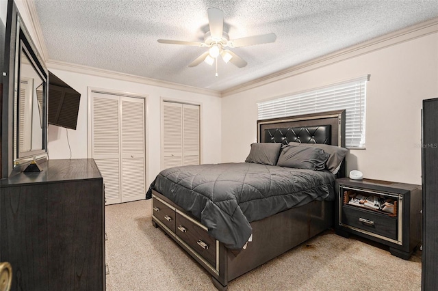 bedroom featuring multiple closets, a textured ceiling, crown molding, light colored carpet, and ceiling fan