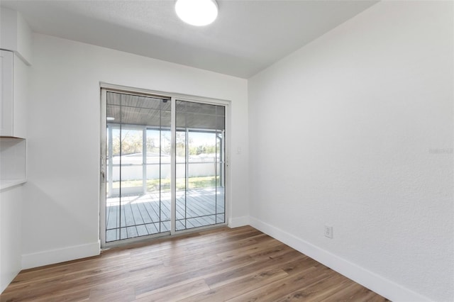 unfurnished room featuring baseboards and light wood-style floors