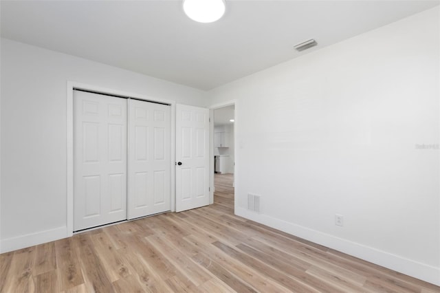 unfurnished bedroom with light wood-style floors, visible vents, and baseboards