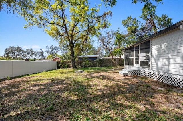 view of yard with a fenced backyard and a sunroom