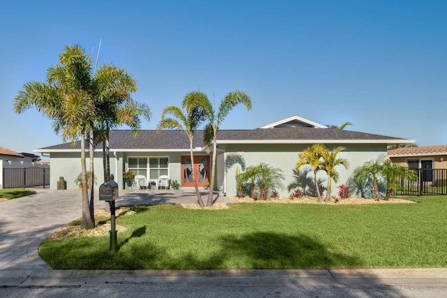 single story home featuring stucco siding, a front yard, and fence