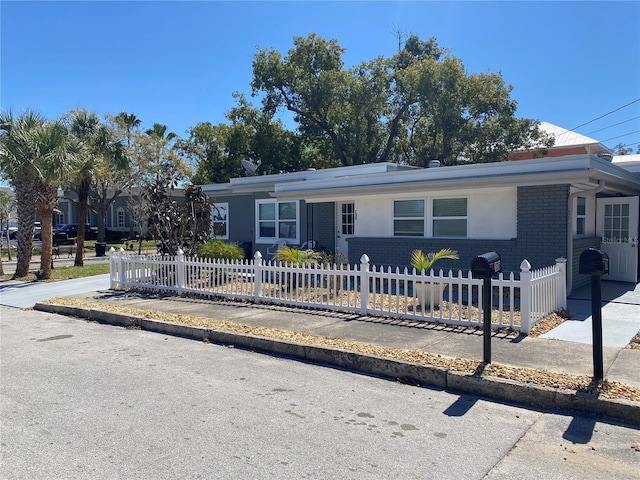 view of front of property with a fenced front yard and brick siding