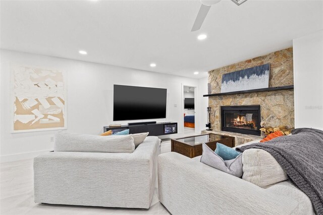 living room featuring a stone fireplace, recessed lighting, a ceiling fan, and wood finished floors