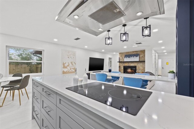 kitchen with hanging light fixtures, recessed lighting, a fireplace, and black electric cooktop