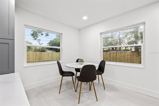 dining area with light wood-style flooring, recessed lighting, baseboards, and a wealth of natural light