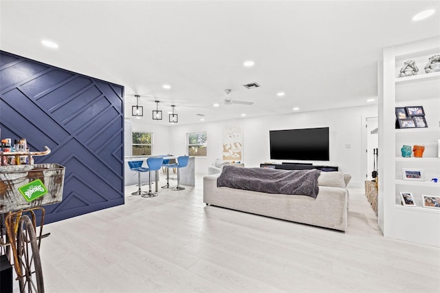 living area featuring visible vents, a dry bar, recessed lighting, wood finished floors, and a ceiling fan