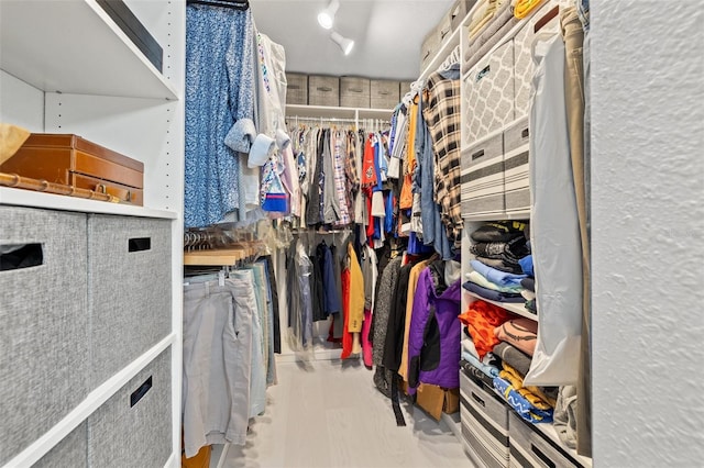 walk in closet with wood finished floors