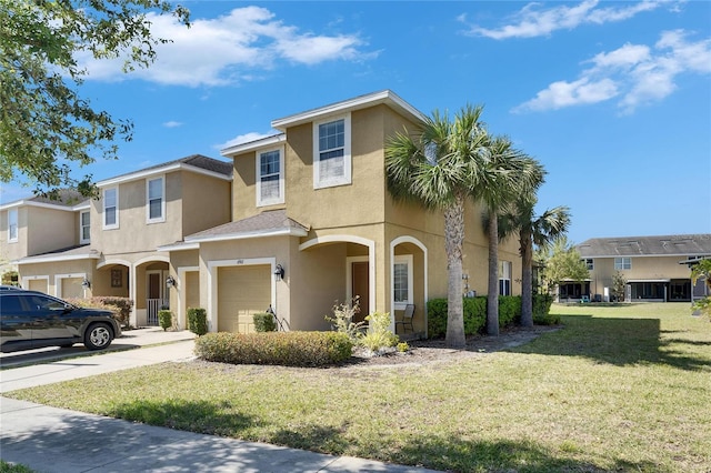 view of front of home with stucco siding, driveway, a garage, and a front yard