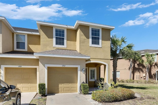 view of property with concrete driveway, a garage, and stucco siding