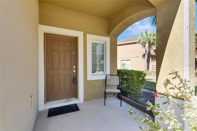 doorway to property featuring stucco siding