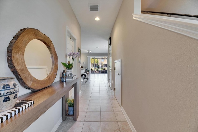 hall with light tile patterned flooring, visible vents, recessed lighting, and baseboards