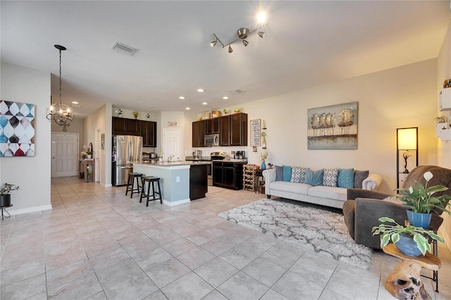 living room featuring visible vents, recessed lighting, an inviting chandelier, light tile patterned flooring, and baseboards