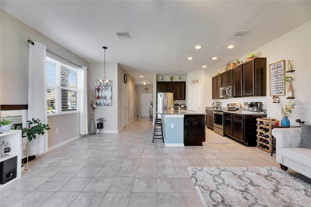 kitchen with visible vents, dark brown cabinets, pendant lighting, appliances with stainless steel finishes, and a kitchen breakfast bar